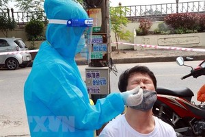 Lấy mẫu test nhanh đối với người dân khu vực ngõ 587, đường Trần Nhân Tông, phường Vị Hoàng, thành phố Nam Định sau khi ở đây ghi nhận 2 ca mắc COVID-19. (Ảnh: Nguyễn Lành/TTXVN).