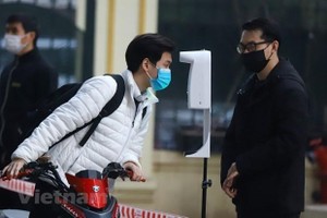 Học sinh được đo thân nhiệt và khử khuẩn tại khu vực cổng trường trước khi lên lớp. (Ảnh: Hoài Nam/Vietnam+).