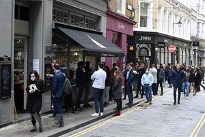 Người dân xếp hàng mua đồ bên ngoài một cửa hàng ở London (Anh), ngày 29/4/2021. (Ảnh: AFP/TTXVN).