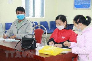 Người lao động đến giải quyết chế độ tại cơ quan Bảo hiểm xã hội huyện Quỳnh Lưu, tỉnh Nghệ An. (Ảnh: Bích Huệ/TTXVN).