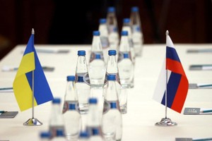 Cờ Ukraine và Nga trên bàn đàm phán của 2 bên. Ảnh: Reuters.