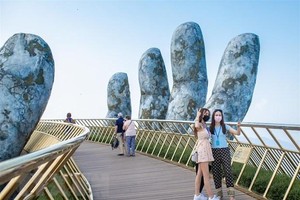 Du khách tham quan chụp ảnh tại cầu Vàng. (Ảnh: TTXVN phát).