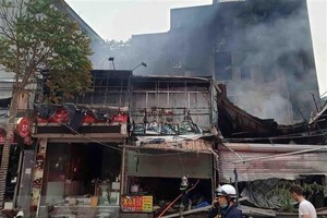 Hiện trường vụ cháy tại địa chỉ ở số 63 Nguyễn Hoàng lan ra nhiều nhà xung quanh. (Ảnh: TTXVN phát).