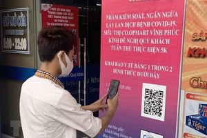 Người dân thực hiện quét mã QR khai báo y tế. (Ảnh: Hoàng Hùng/TTXVN)