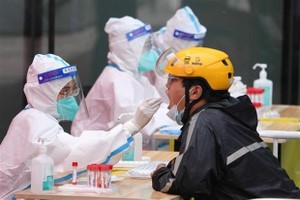 Nhân viên y tế lấy mẫu xét nghiệm COVID-19 cho người dân tại Bắc Kinh, Trung Quốc ngày 5/5/2022. (Ảnh: THX/TTXVN).