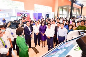 Ban Lãnh đạo Vietcombank giới thiệu về sản phẩm dịch vụ của Vietcombank với đoàn đại biểu do Thủ tướng Chính Phủ Phạm Minh Chính (hàng đầu thứ hai từ phải sang) dẫn đầu tại sự kiện