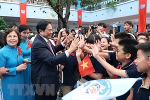 Thủ tướng Phạm Minh Chính với học sinh Trường Tiểu học Đoàn Thị Điểm. (Ảnh: Dương Giang/TTXVN).