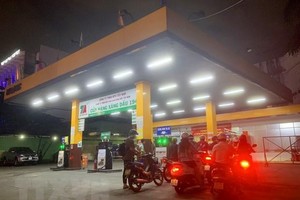 Người dân mua xăng tại Cửa hàng xăng dầu trên đường Hoàng Văn Thụ (quận Phú Nhuận, Thành phố Hồ Chí Minh), tối ngày 12/10. (Ảnh: Hồng Đạt/TTXVN)