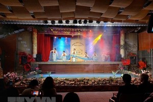 Du khách thưởng thực chương trình nghệ thuật truyền thống tại tour khám phá Hoàng thành Thăng Long về đêm. (Ảnh: Đinh Thuận/TTXVN)