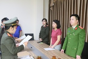 Cơ quan chức năng tống đạt các quyết định khởi tố, bắt tạm giam Nguyễn Thanh Thủy - Giám đốc Công ty cổ phần Công nghệ thông tin Lam Hồng. (Ảnh: TTXVN phát)