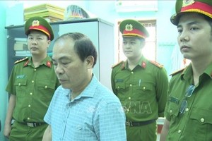 Đại diện Cơ quan công an đọc lệnh khởi tố bị can đối với Đinh Văn Khoa. Ảnh: TTXVN phát