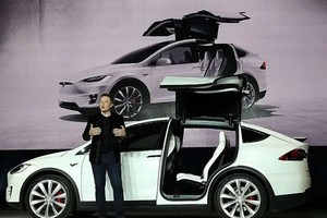 Tỷ phú Elon Musk đứng cạnh một mẫu xe điện của Tesla. (Ảnh: Getty Images).