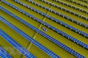 Công nhân điện kiểm tra các tấm năng lượng mặt trời tại nhà máy điện mặt trời ở Hải An, tỉnh Giang Tô, Trung Quốc. (Ảnh: AFP/TTXVN).