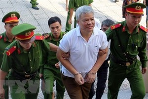 Lực lượng chức năng dẫn giải bị cáo Nguyễn Văn Khuê vào phòng xét xử. (Ảnh: Vũ Hà/TTXVN)