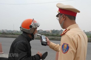 Cảnh sát giao thông kiểm tra nồng độ cồn của người điều khiển phương tiện. (Ảnh minh họa. Thùy Dung/TTXVN)