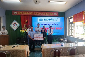 Ông Lê Trọng Minh, Tổng Biên tập Báo Đầu tư trao biểu trưng học bổng cho đại diện nhà trường.
