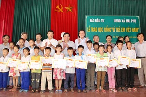 Ông Nguyễn Trí Dũng, Ủy viên Trung ương Đảng, Thứ trưởng Thường trực Bộ Kế hoạch và Đầu tư và Tổng Biên tập Báo Đầu tư Nguyễn Anh Tuấn trao học bổng cho các em học sinh huyện Lộc Hà (Hà Tĩnh)