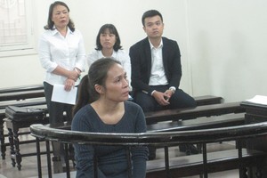 Bị cáo (nữ áo đen hàng trên) tại tòa