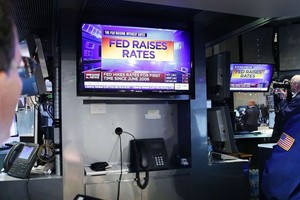 Giới đầu tư theo dõi thông tin Fed tăng lãi suất (Ảnh: AFP)