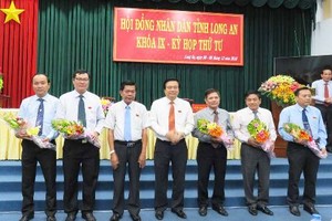 Bí thư Tỉnh ủy,Chủ tịch HĐND tỉnhLong An - Phạm Văn Rạnh (đứng giữa) và Chủ tịch UBND tỉnh - Trần Văn Cần (thứ 3 bên trái qua) tặng hoa chúc mừng các đồng chí ủy viên UBND tỉnh được miễn nhiệm và bầu bổ sung. Ảnh Báo Long An