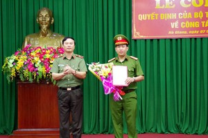 Thiếu tướng Bùi Minh Giám, Phó Tổng cục trưởng Tổng cục chính trị Công an nhân dân trao quyết định và tặng hoa chúc mừng Thượng tá  Lục Thế Hưng, tân phó giám đốc Công an tỉnh Hà Giang