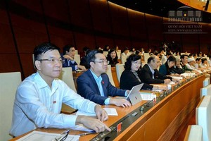 Các đại biểu Quốc hội nhấn nút thông qua Nghị quyết (ảnh: Quochoi.vn)