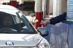 Tài xế trả tiền lẻ qua trạm BOT quốc lộ 5. Ảnh: Ngọc Thành