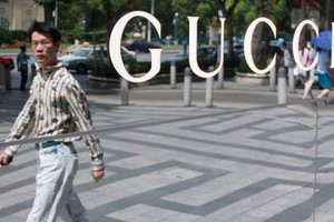 Một người đàn ông đi qua cửa hàng Gucci tại Thượng Hải, Trung Quốc. Ảnh:CNN