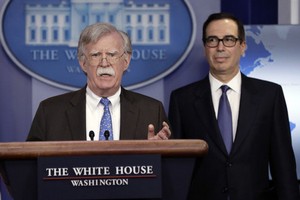 Cố vấn Bolton (trái) và Bộ trưởng Mnuchin công bố lệnh cấm vận. Ảnh:AFP.