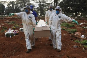 Công nhân mặc đồ bảo hộ chôn cất nạn nhân Covid-19 tại nghĩa trang ở ngoại ô Sao Paulo, Brazil hôm 20/5. Ảnh: Reuters.