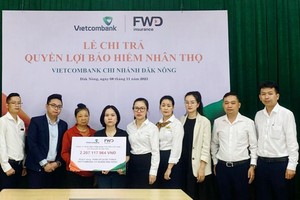 Đại diện Vietcombank Đăk Nông và FWD thực hiện chi trả quyền lợi bảo hiểm cho khách hàng