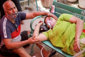 Người dân được hỗ trợ oxy miễn phí do bị khó thở bên ngoài Gurudwara (đền thờ Sikh) trong bối cảnh lây lan dịch bệnh Covid-19 ở Ấn Độ ngày 3/5/2021.