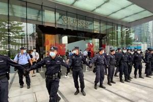 Các nhân viên an ninh tạo thành một chuỗi người khi họ bảo vệ trụ sở của Evergrande, nơi mọi người tụ tập để yêu cầu hoàn trả các khoản vay và các sản phẩm tài chính ở Thâm Quyến, Trung Quốc