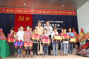  Ông Nguyễn Anh Tuấn, Tổng biên tập Báo Đầu tư và ông Võ Văn Chính, Phó Trưởng phòng Cảnh sát giao thông tỉnh Quảng Bình trao cặp phao cứu sinh cho học sinh xã Quảng Minh.