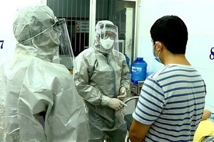 Nhân viên y tế thực hiện các biện pháp nghiệp vụ với bệnh nhân nghi mắc nCoV. (Ảnh: Thành Chung/TTXVN)