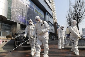 Nhân viên y tế phun thuốc khử trùng trước một nhà thờ ở Daegu, Hàn Quốc. Ảnh: AP.