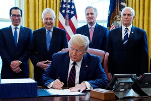 Tổng thống Mỹ Donald Trump ký gói cứu trợ Covid-19 tại Nhà Trắng ngày 27/3. Phía sau từ trái qua bao gồm Bộ trưởng Tài chính Steven Mnuchin, Lãnh đạo đa số tại Thượng viện Mitch McConnell,  Lãnh đạo thiểu số tại Hạ viện Kevin McCarthy và Phó Tổng thống Mike Pence. Ảnh: AP.