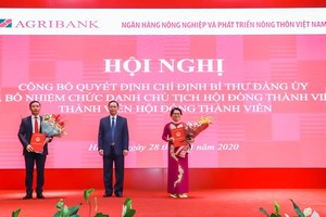 Phó Thống đốc Đào Minh Tú (đứng giữa) trao quyết định cho ông Phạm Đức Ấn (bên tay trái) và bà Đỗ Thị Nhàn (bên tay phải)