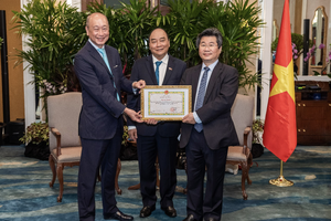 Ông Wee Ee Cheong, Phó chủ tịch kiêm Tổng giám đốc tập đoàn UOB, nhận bằng khen từ ông Đỗ Nhất Hoàng, Cục trưởng Cục Đầu tư nước ngoài trước sự chứng kiến của Chủ tịch nước Nguyễn Xuân Phúc