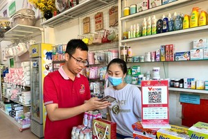 Cán bộ Agribank hướng dẫn khách hàng sử dụng dịch vụ số - nền tảng để thay đổi thói quen thanh toán bằng tiền mặt