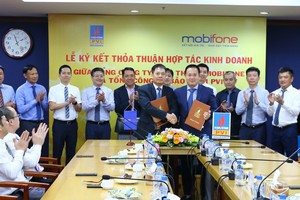 Ông Tô Mạnh Cường, Tổng giám đốc MobiFone (ở giữa, bên trái) và ông giám đốc Tổng công ty Bảo hiểm PVI (ở giữa, bên phải) ký kết Thỏa thuận hợp tác