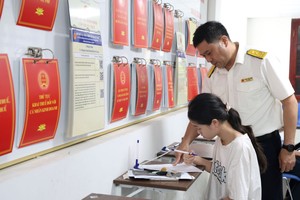 Công chức thuế hướng dẫn người dân làm thủ tục kê khai thuế. Ảnh: Dũng Minh