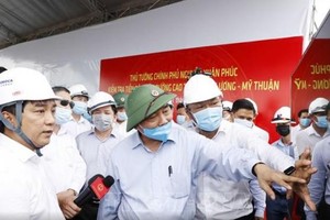 Ông Hồ Minh Hoàng (mặc áo trắng) báo cáo Thủ tướng Chính phủ Nguyễn Xuân Phúc tiến độ xây dựng đường cao tốc Trung Lương - Mỹ Thuận trong chuyến công tác thị sát Dự án vào cuối tháng 7/2020.