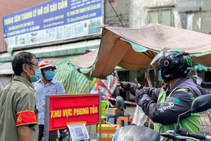 Tài xế giao hàng của GoJek Việt Nam giao hàng đến khu vực phong toả (Ảnh: Q.T).