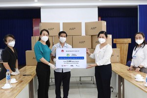 Bà Nguyễn Thị Toại,Trưởng đại diện Văn phòng phía Nam Bộ Kế hoạch và Đầu tư tại TP.HCM và ông Đào Minh Chánh, Phó giám đốc Sở Kế hoạch và Đầu Tư TP.HCM trao số khẩu trang cho bà Nguyễn Thị Huỳnh Mai ( cầm bảng, phải) Chánh Văn phòng Sở Y tế TP.HCM. Ảnh: Lê Toàn