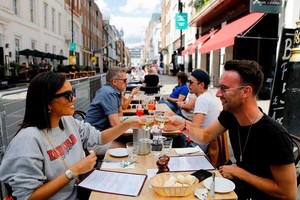 Thực khách thưởng thức đồ uống tại một nhà hàng ở London, hưởng ứng chương trình kích cầu EOHO của chính phủ Anh. Ảnh: AFP 