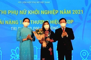 Phó Thủ tướng Thường trực Phạm Bình Minh và Chủ tịch Hội Liên hiệp Phụ nữ Việt Nam Hà Thị Nga trao Giải "Nâng tầm thương hiệu OCOP" cho tác giả Vi Thị Lụa với dự án "Trà diếp cá Lụa Vy"