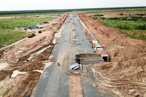 Thi công hoàn thiện tuyến đường chính trong Khu tái định cư Lộc An - Bình Sơn. (Ảnh: Công Phong/TTXVN)