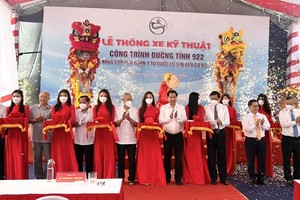 Bí thư Thành ủy Cần Thơ Lê Quang Mạnh (thứ 4 từ phải sang) cùng các đại biểu thực hiện nghi thức cắt băng thông xe kỹ thuật Đường tỉnh 922. Ảnh: Anh Khoa
