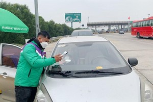 Nhân viên VETC dán thẻ Etag cho các phương tiện lưu thông qua cao tốc Hà Nội - Hải Phòng.